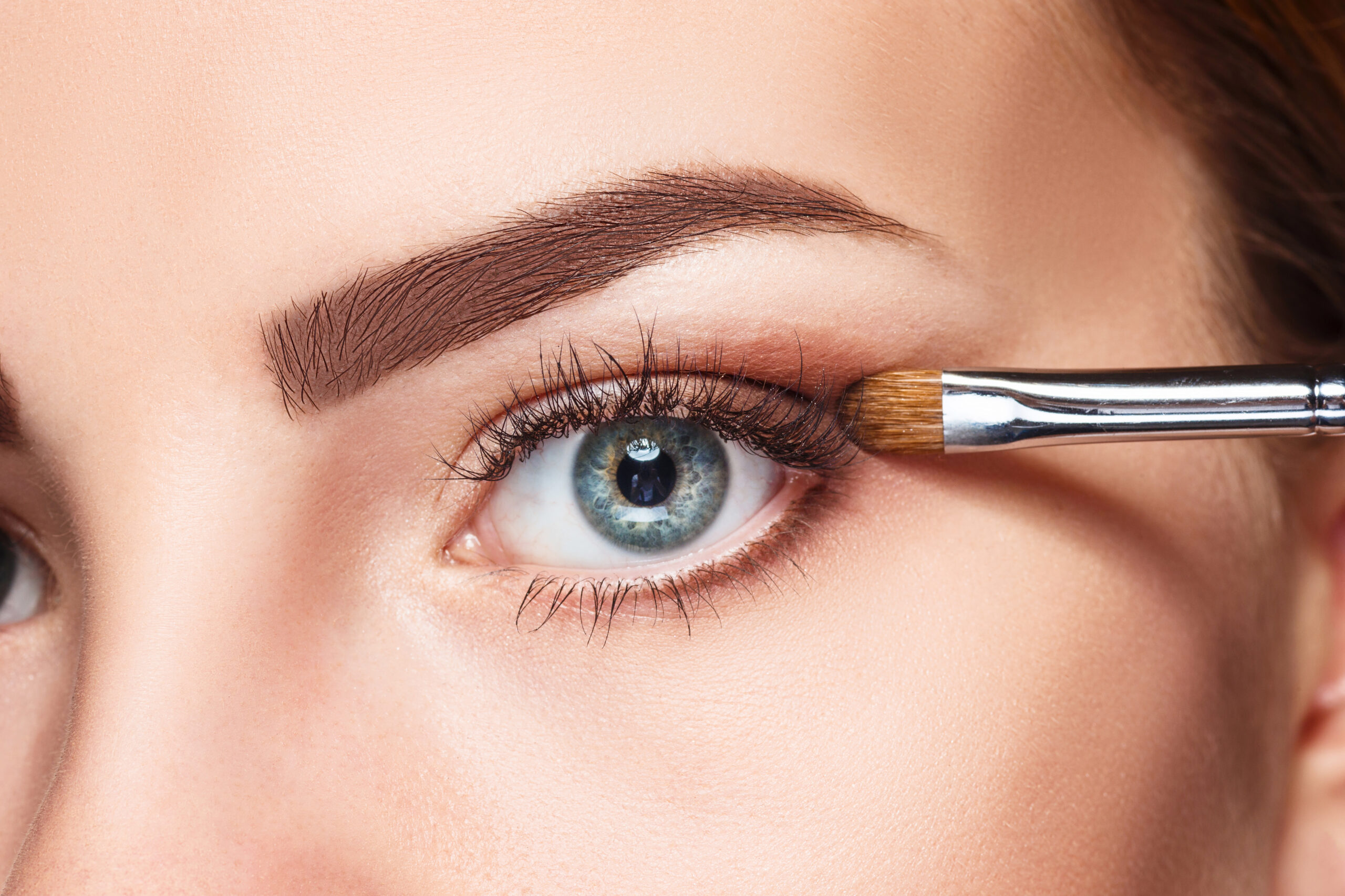 Beautiful female eyes with make-up and brush